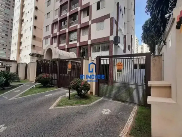 A imagem é a fachada do residencial canoeiros no setor bueno uma área urbana, com um foco na entrada principal e nos detalhes de segurança. A cena é iluminada pela luz do dia, e a composição equilibra elementos arquitetônicos com áreas verdes. Edifício: Altura e Estrutura: O prédio é alto, composto por múltiplos andares. A arquitetura sugere um design moderno, mas com alguns elementos decorativos mais tradicionais. Fachada: A fachada combina painéis em tons claros, possivelmente bege ou branco, com detalhes quadriculados em tons de tijolo ou marrom avermelhado. Esses detalhes criam um padrão visual interessante, quebrando a monotonia da fachada. Janelas: As janelas são padronizadas, retangulares e dispostas de forma simétrica em cada andar. Elas parecem ser de vidro claro com molduras claras ou metálicas. Entrada: A entrada principal do prédio é emoldurada por uma estrutura arqueada, que se projeta para a frente. Essa área é sombreada e pode ter detalhes adicionais, como luminárias. Ar Condicionado: Em uma das laterais do prédio, é possível observar aparelhos de ar condicionado instalados nas janelas, indicando que o sistema de climatização é individual. Portão e Entrada: Material e Design: O portão é feito de metal, possivelmente ferro forjado, e tem um design com barras verticais e detalhes ornamentais. A cor é um tom escuro, como marrom ou preto, que contrasta com a vegetação ao redor. Segurança: Há avisos de segurança fixados no portão, indicando a presença de vigilância ou de um sistema de segurança ativo. Paisagismo: A área ao redor do portão é bem cuidada, com grama aparada e arbustos decorativos. Há um caminho de pedra que leva do portão até a entrada do prédio. Iluminação: Uma pequena luminária está presente em meio à vegetação próxima ao portão, sugerindo iluminação noturna para a área. Segurança Adicional: Muro e Arame Farpado: À direita da imagem, há um muro que delimita a propriedade. No topo do muro, há arame farpado, indicando uma preocupação adicional com a segurança do local. Sistema de Alarme: Também visível na parede, encontra-se um sistema de alarme com luzes de advertência, reforçando a segurança do prédio. Ambiente: Vegetação: A presença de árvores e arbustos ao redor do prédio sugere que ele está localizado em uma área com alguma vegetação, possivelmente um bairro residencial com áreas verdes. Pavimentação: O chão é pavimentado com pedras, criando um padrão interessante e funcional para o trânsito de veículos e pedestres. Céu: O céu azul claro indica um dia ensolarado, contribuindo para uma atmosfera geral positiva na imagem. Logotipo: G1 Imóveis: No centro da imagem, sobre o portão, há um logotipo da imobiliária "G1 Imóveis". Em resumo, a imagem detalha um edifício de apartamentos com uma fachada bem cuidada, um portão de entrada com segurança reforçada e um paisagismo que valoriza a área. A combinação de elementos arquitetônicos e naturais cria uma atmosfera convidativa e segura.