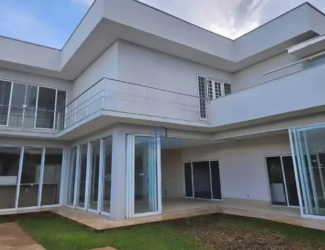 Fachada de sobrado moderno de alto padrão com grandes vidraças e varanda no Condomínio Jardins Atenas.