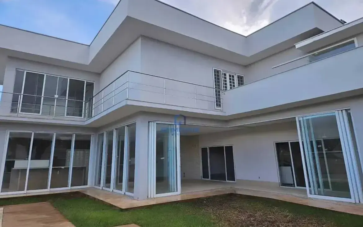 Fachada de sobrado moderno de alto padrão com grandes vidraças e varanda no Condomínio Jardins Atenas.