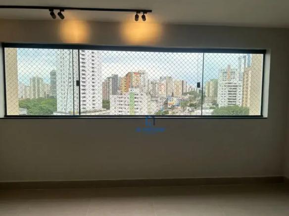 Janela e Vista: Detalhes da Tela de Proteção: A tela de proteção é composta por uma malha fina de fios, possivelmente de nylon ou material similar, entrelaçados em pequenos quadrados. É possível ver os pontos de fixação da tela na moldura da janela, que parecem ser pequenos ganchos ou presilhas discretas. Vidro da Janela: Apesar de a tela ser o foco, é possível notar que o vidro da janela parece ser duplo, o que sugere um bom isolamento acústico e térmico do ambiente. Reflexos sutis no vidro indicam a presença de luz no interior. Céu e Cores da Cidade: Através da tela, o céu aparece levemente nublado, com tons de azul claro e branco acinzentado. Os edifícios da cidade exibem uma variedade de cores, desde o branco e o cinza predominantes até toques de laranja, verde e amarelo em alguns prédios mais baixos. A disposição dos edifícios cria uma sensação de profundidade e perspectiva. Vegetação: A vegetação na parte inferior da vista da cidade é densa e variada, com diferentes tons de verde que indicam a presença de árvores de diferentes espécies. É possível discernir a copa de algumas árvores maiores, o que sugere a existência de parques ou áreas de preservação próximas. Paredes e Piso: Textura da Parede: A pintura das paredes parece ser lisa e uniforme, mas uma análise mais atenta revela uma leve textura, possivelmente resultante da aplicação da tinta com rolo. Essa textura sutil adiciona um toque de interesse visual à superfície. Rodapé Detalhado: O rodapé possui um perfil discreto, com uma pequena saliência que acompanha a base da parede. A junção entre o rodapé e o piso é precisa e bem acabada. Piso Refletivo: O piso de cerâmica ou porcelanato exibe um leve brilho, o que indica que possui uma superfície polida. Essa característica contribui para a sensação de amplitude e luminosidade do ambiente. As juntas entre as placas do piso são finas e regulares, o que demonstra a qualidade da instalação. Iluminação: Spots de Luz: Os spots de luz no trilho do teto são cilíndricos e possuem um acabamento fosco na cor preta. É possível notar que os spots são direcionáveis, o que permite ajustar o foco da luz de acordo com a necessidade. A luz emitida pelos spots é quente e suave, criando uma atmosfera acolhedora. Sombras: As sombras projetadas pelas luminárias no teto e nas paredes adicionam profundidade e dimensão ao ambiente. A luz natural que entra pela janela cria um jogo de luz e sombra que varia ao longo do dia. Detalhes Adicionais: Ausência de Objetos: A ausência de móveis, quadros ou outros objetos de decoração no ambiente chama a atenção para a arquitetura e a vista. Isso sugere que o espaço está recém-construído ou em fase de preparação para ser mobiliado. Sensação de Espaço: A combinação de cores claras, luz natural abundante e a vista panorâmica da cidade cria uma forte sensação de espaço e amplitude no ambiente. A ausência de elementos decorativos reforça essa impressão.