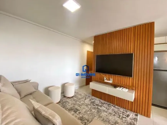 A imagem apresenta um espaço de convivência moderno e convidativo, caracterizado por uma paleta de cores neutras e materiais contrastantes. A iluminação é uniforme e suave, destacando os detalhes dos móveis e da decoração. Paredes e Iluminação: As paredes são pintadas em um branco suave, possivelmente um tom off-white, que reflete a luz natural e artificial. Há um rodapé branco fino que percorre toda a extensão da parede, criando uma separação limpa entre a parede e o piso. No teto, uma luminária quadrada embutida emite uma luz difusa e uniforme, iluminando toda a área. Mobiliário: Sofá: O sofá é do tipo secional, com um tom bege claro que se harmoniza com o restante da decoração. Ele possui almofadas macias e convidativas, com diferentes tamanhos e texturas. Pufes: Dois pufes cilíndricos brancos servem como assentos adicionais ou apoio para os pés. Eles têm um acabamento liso e clean. Rack: O rack flutuante abaixo da TV é branco e possui um design minimalista. Ele oferece espaço para acomodar aparelhos eletrônicos, como um roteador Wi-Fi (visível pelos cabos conectados) e outros dispositivos. Detalhes de Decoração e Acabamento: Parede de Madeira: A parede de madeira vertical é um elemento marcante na sala. Ela é composta por ripas de madeira estreitas e verticais, com um tom marrom-médio que adiciona calor e textura ao espaço. A TV de tela plana está fixada nesta parede, criando um ponto focal. Tapete: O tapete é um dos elementos mais texturizados da sala. Ele possui um padrão abstrato em tons de cinza e branco, com um visual desgastado ou sutilmente manchado. Suas fibras parecem macias e aconchegantes. Cozinha: No fundo, a cozinha apresenta uma geladeira de aço inoxidável com um acabamento escovado. Os armários são brancos e têm um design moderno e clean. Uma pequena parte da bancada também é visível. Porta: Ao lado da parede de madeira, uma porta de madeira maciça em tom marrom-médio oferece acesso a outra área do apartamento. A porta tem um design simples e funcional. Atmosfera Geral: A sala de estar transmite uma sensação de conforto, organização e modernidade. A combinação de cores neutras, materiais naturais (como a madeira) e elementos de design minimalistas cria um ambiente agradável e convidativo. A iluminação suave e a disposição dos móveis favorecem o relaxamento e a convivência.