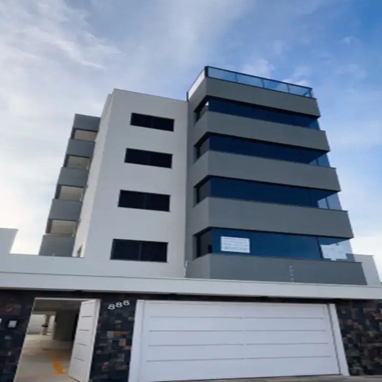 Fachada de prédio moderno no bairro Santa Mônica, Uberlândia (MG), com design minimalista em branco e cinza, varandas de vidro e muro de pedra na entrada.