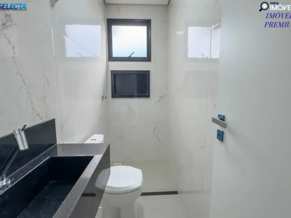 A imagem apresenta o banheiro de um apartamento à venda no bairro Santa Mônica, em Uberlândia, MG, destacando um ambiente moderno e sofisticado. O banheiro exibe um design contemporâneo, com predominância de cores neutras como branco e cinza, que conferem um visual limpo e elegante. A arquitetura é caracterizada por linhas retas e acabamentos de alta qualidade, sugerindo um padrão premium. O ambiente do banheiro parece ser espaçoso e bem iluminado, com detalhes que evidenciam cuidado e sofisticação, como piso e revestimentos de alta qualidade, iluminação estratégica e possivelmente acessórios modernos. O estilo do imóvel reflete um alto padrão, com atenção aos detalhes que proporcionam conforto e funcionalidade. A localização no bairro Santa Mônica, conhecido por sua infraestrutura completa e tranquilidade, é um dos pontos fortes do imóvel. A imagem transmite a ideia de um apartamento de luxo, perfeito para quem deseja viver em um ambiente moderno, confortável e bem localizado em uma das áreas mais valorizadas de Uberlândia.