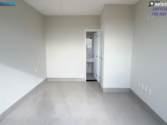 A imagem apresenta um quarto de um apartamento à venda no bairro Santa Mônica, em Uberlândia, MG, destacando um ambiente moderno e acolhedor. O quarto exibe um design contemporâneo, com predominância de cores neutras como bege e tons de cinza, que conferem um visual tranquilo e sofisticado. A arquitetura é caracterizada por linhas limpas e acabamentos de alta qualidade, sugerindo um padrão premium. O ambiente do quarto parece ser espaçoso e bem iluminado, com detalhes que evidenciam cuidado e conforto, como pisos de madeira clara, cortinas elegantes e iluminação suave que cria uma atmosfera relaxante. O estilo do imóvel reflete um alto padrão, com atenção aos detalhes que proporcionam funcionalidade e bem-estar. A localização no bairro Santa Mônica, conhecido por sua infraestrutura completa e tranquilidade, é um dos pontos fortes do imóvel. A imagem transmite a ideia de um apartamento de luxo, perfeito para quem deseja viver em um ambiente moderno, confortável e bem localizado em uma das áreas mais valorizadas de Uberlândia.