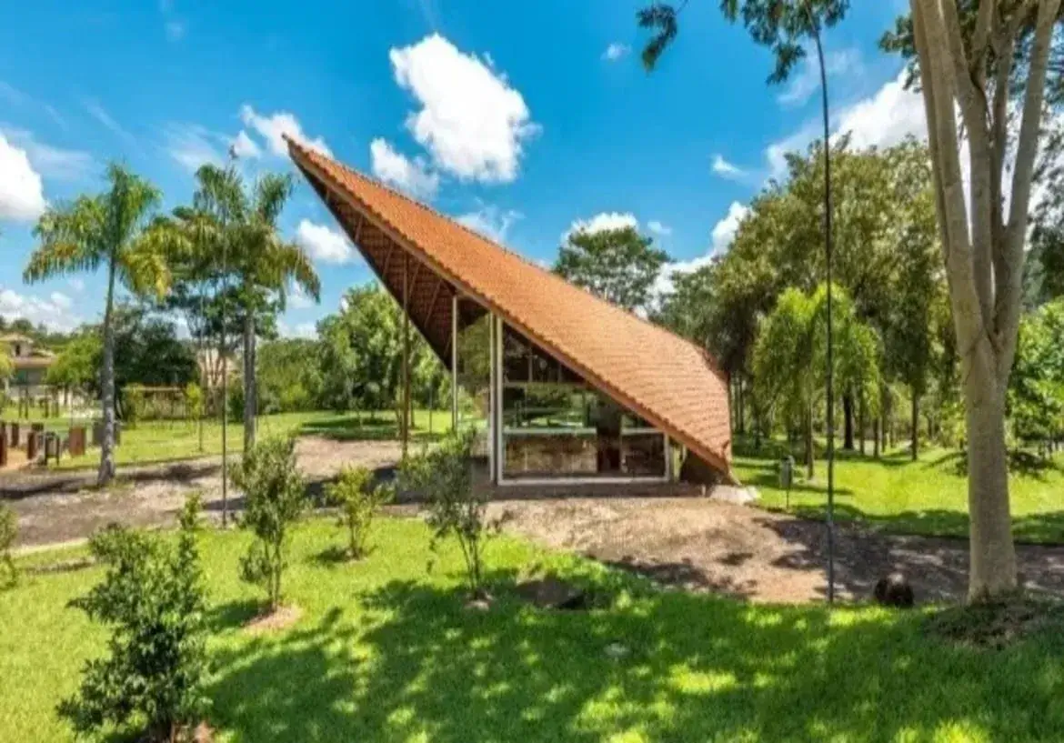 Arquitetura moderna com telhado inclinado e vidro em meio à natureza nas fotos do condomínio aldeia do vale.