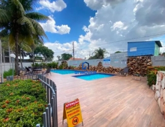 Área de lazer ensolarada com piscina, cascata de pedras e deck no Residencial Hayward.