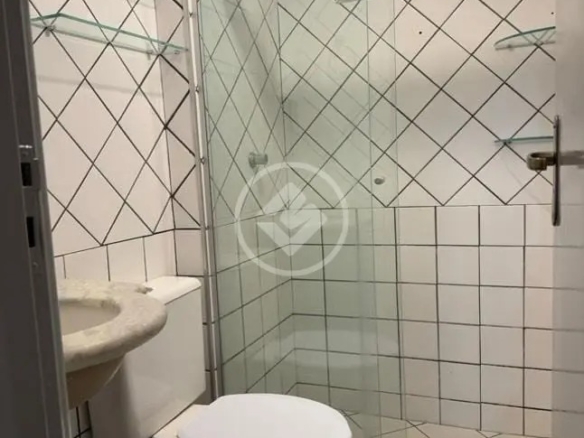 Banheiro completo com box de vidro, azulejos brancos geométricos e pia de granito no Residencial Hayward.