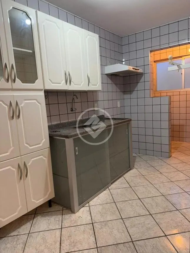 Cozinha com armários brancos, pia de granito escuro e gabinete com portas de vidro no Residencial Hayward.