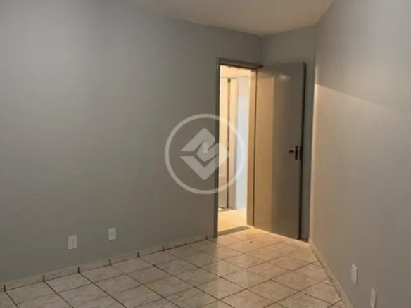 Ângulo do quarto mostrando paredes cinzas, piso frio e porta aberta para o corredor no Residencial Hayward.