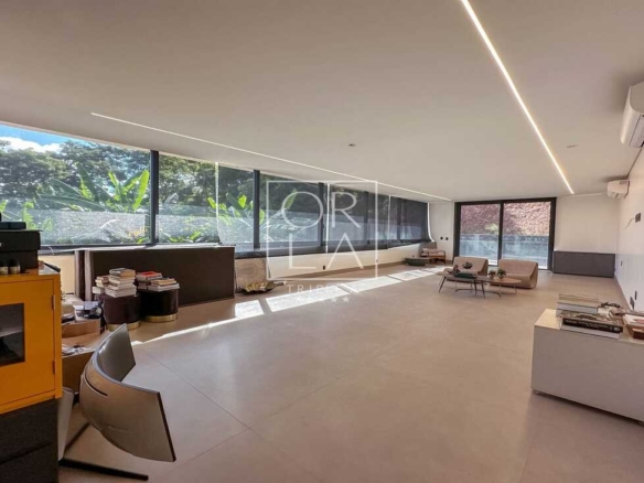 Salão espaçoso e moderno, com balcão e mesa com livros