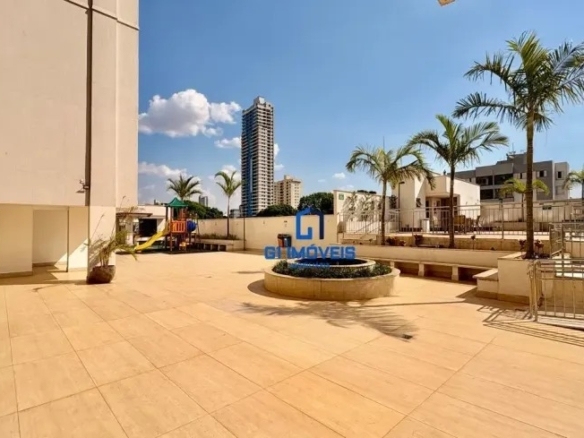 Área comum externa com paisagismo, palmeiras e vista para o skyline urbano no Residencial Auge.