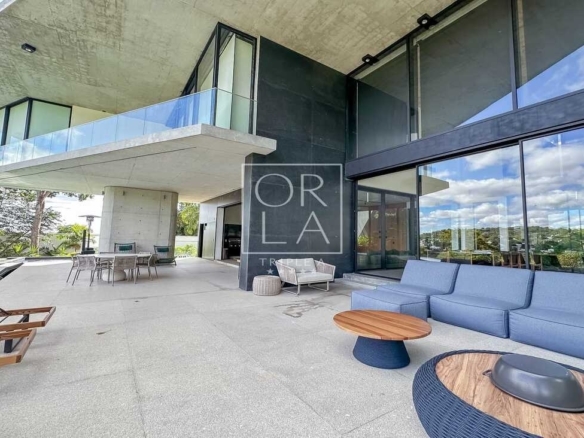 Área de lazer externa com poltronas confortáveis em residência no Aldeia do Vale.