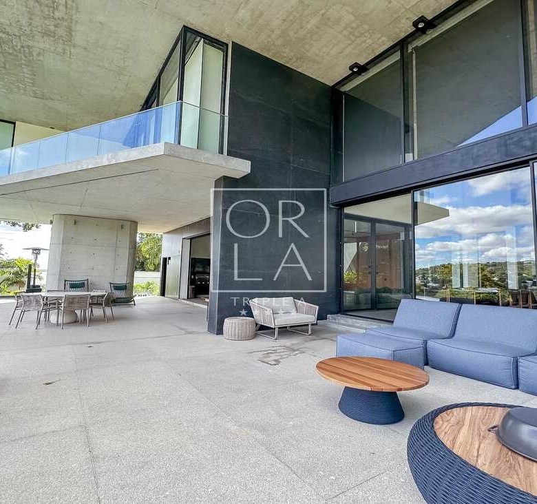 Área de lazer externa com poltronas confortáveis em residência no Aldeia do Vale.