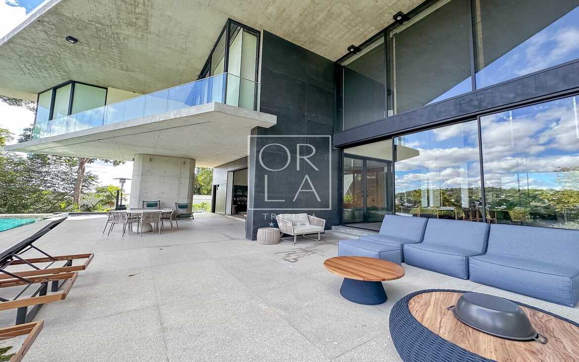 Área de lazer externa com poltronas confortáveis em residência no Aldeia do Vale.