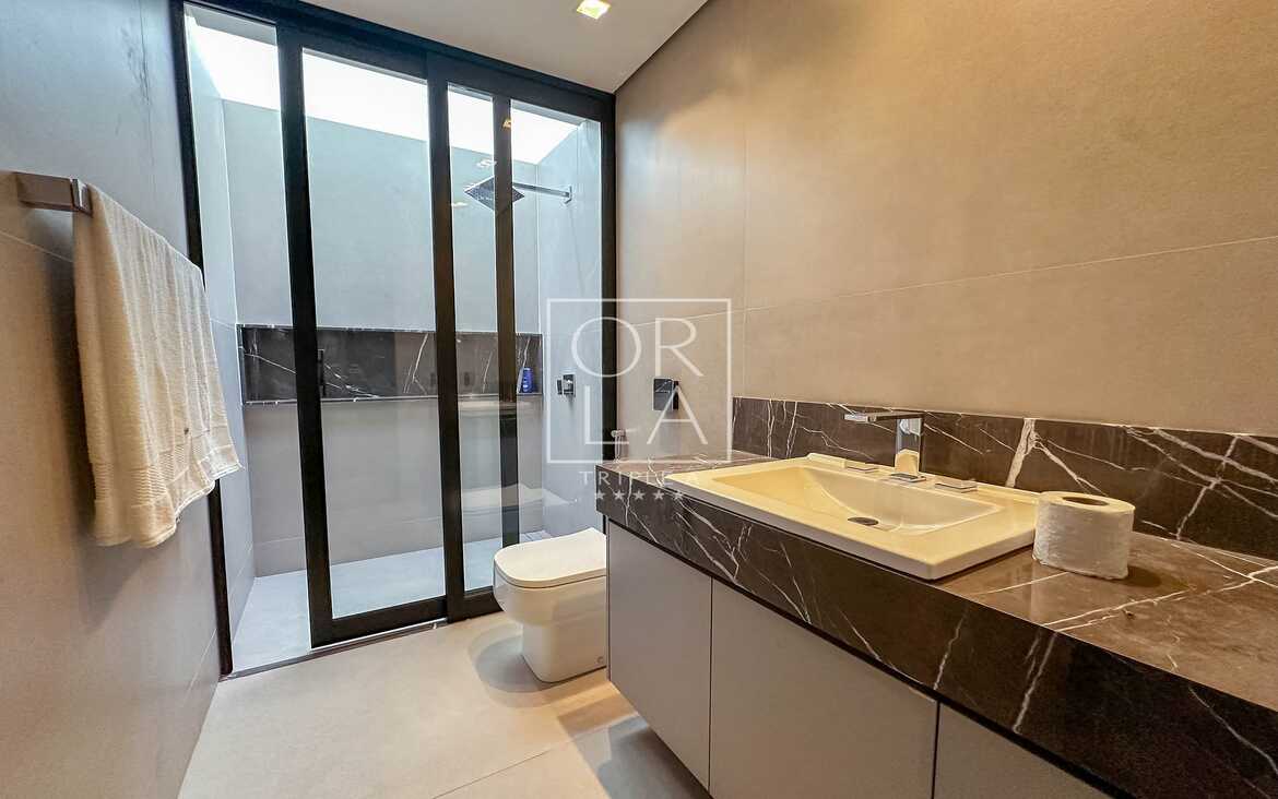 Lavabo de luxo com pia esculpida em pedra natural no Aldeia do Vale.