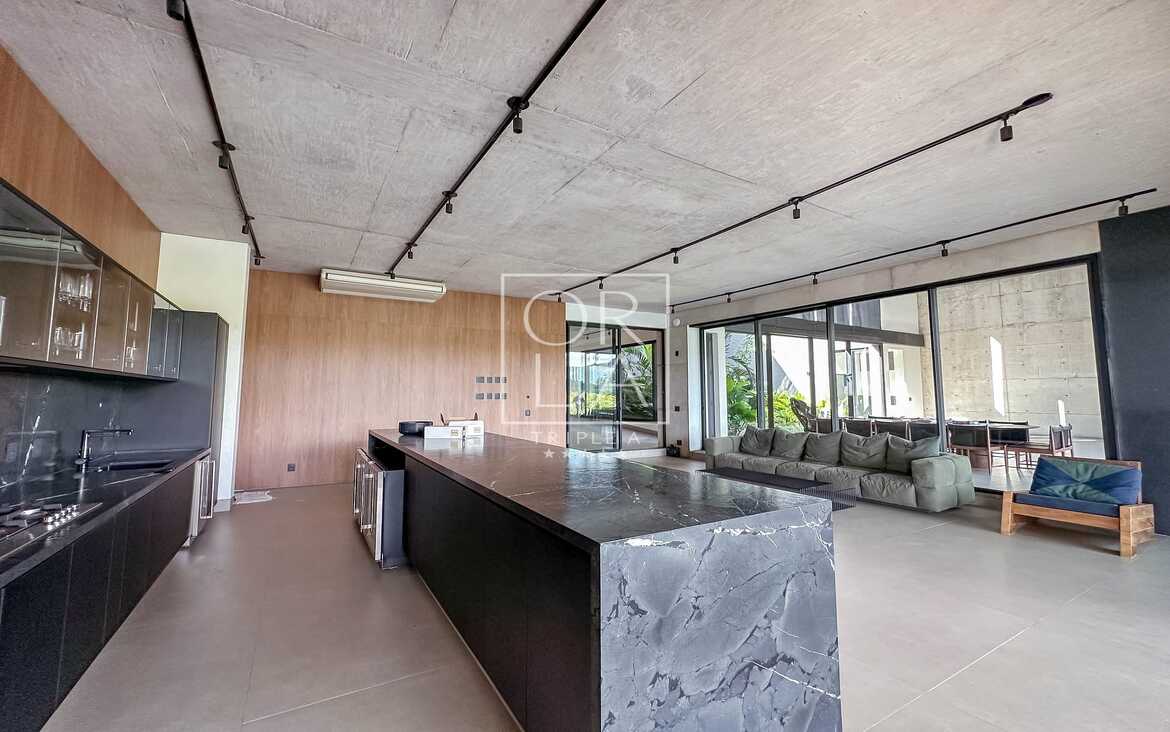 Bancada de cozinha em ilha com acabamento em mármore escuro no Aldeia do Vale.