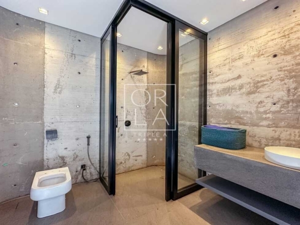 Banheiro moderno com paredes de concreto aparente em imóvel no Aldeia do Vale.