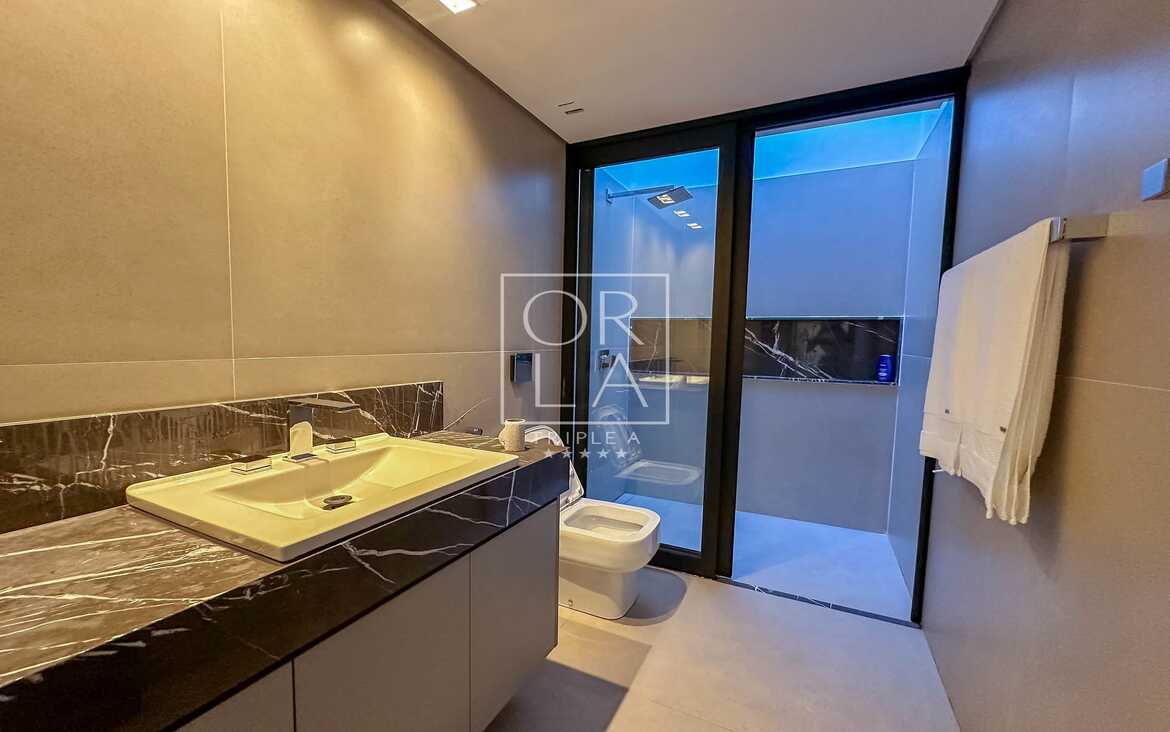 Banheiro com vista para o jardim interno e ventilação natural.