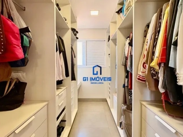 Closet planejado estilo corredor com prateleiras abertas, gaveteiros brancos e organização de roupas e acessórios.