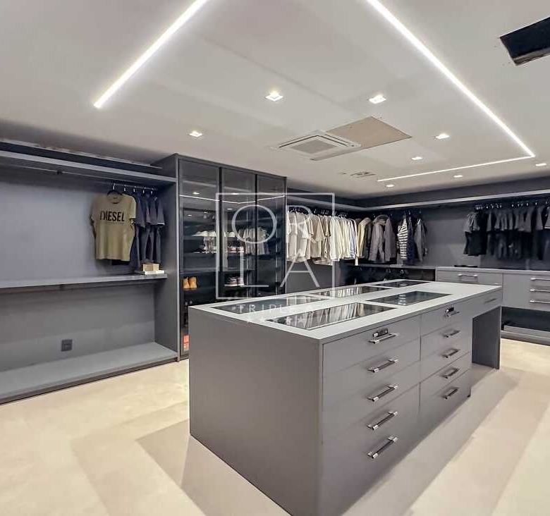 Closet walk-in com ilha central para acessórios e organização impecável.