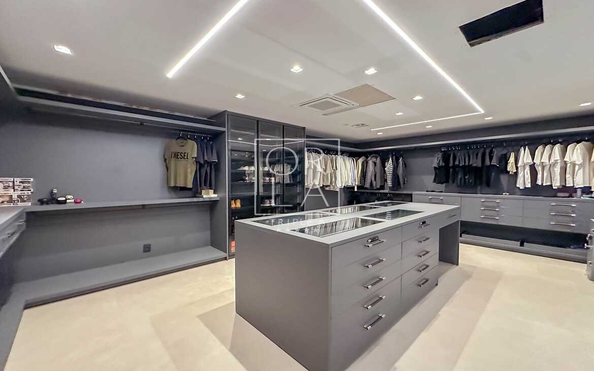 Closet walk-in com ilha central para acessórios e organização impecável.