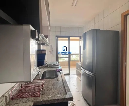 Vista interna da cozinha planejada com pia em granito e eletrodomésticos em inox.