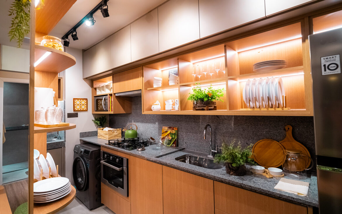 cozinha-planejada-madeira-now-111 Cozinha moderna com armários em madeira, iluminação embutida em prateleiras e utensílios organizados no Now 111.