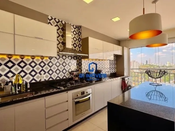 Detalhe de cozinha planejada com armários brancos, fogão embutido e revestimento de parede com padrão geométrico azul e branco.