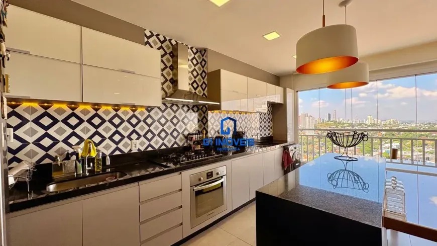 Detalhe de cozinha planejada com armários brancos, fogão embutido e revestimento de parede com padrão geométrico azul e branco.