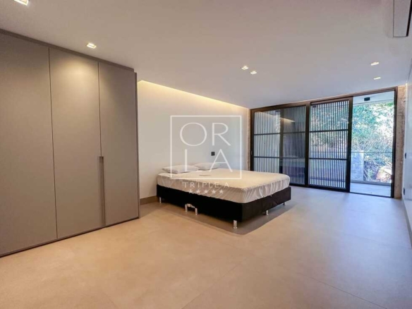 Dormitório com closet integrado e portas de correr em vidro escurecido.