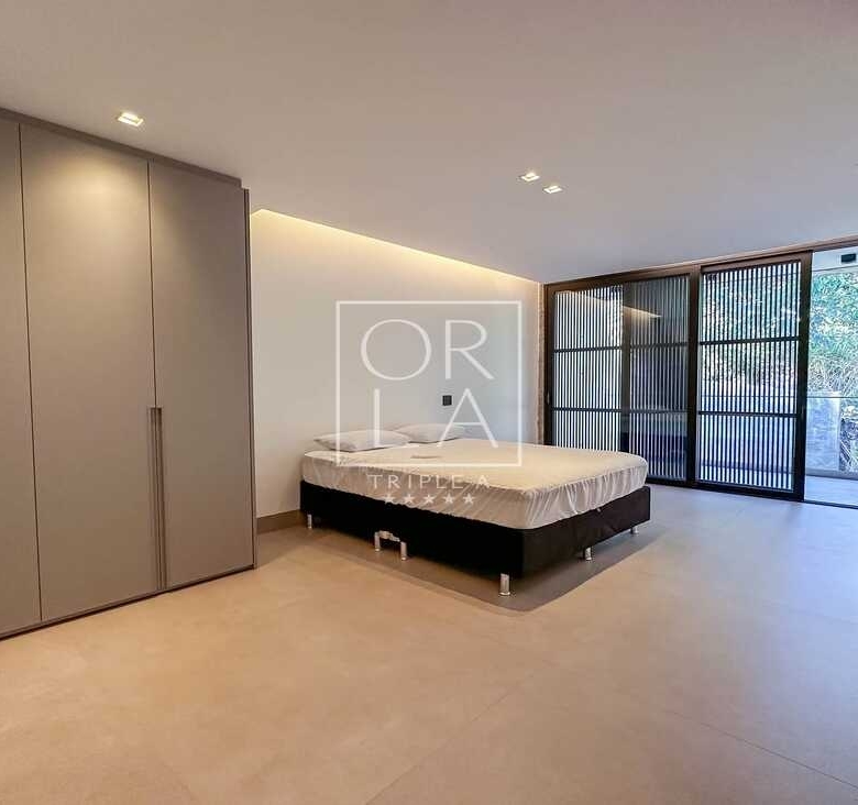 Dormitório com closet integrado e portas de correr em vidro escurecido.