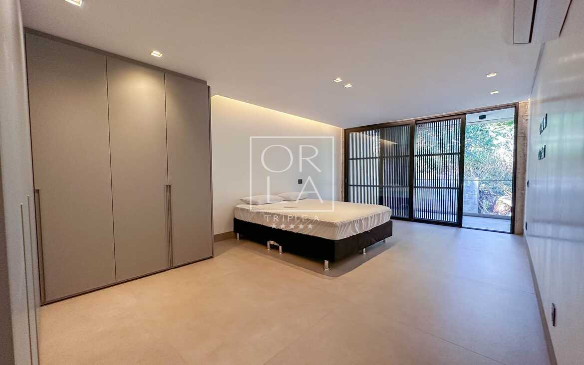 Dormitório com closet integrado e portas de correr em vidro escurecido.