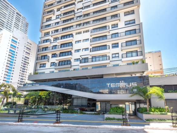 Fachada frontal da entrada do condomínio Tempus by Palme, com design moderno em vidro e acabamento em preto.