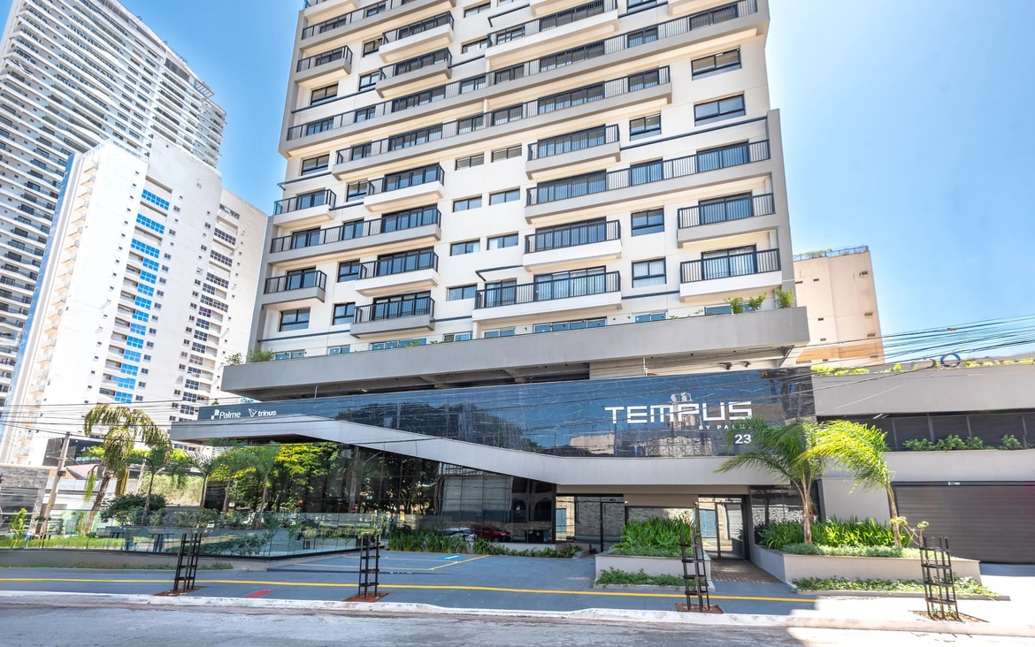 Fachada frontal da entrada do condomínio Tempus by Palme, com design moderno em vidro e acabamento em preto.