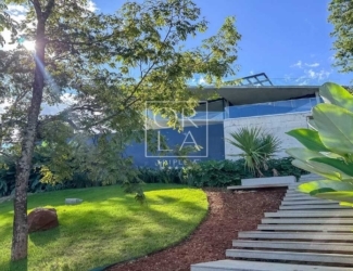 Escada externa em pedra integrada ao jardim e iluminação de balizamento.
