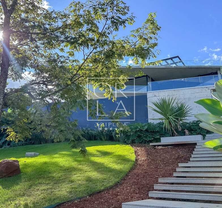 Escada externa em pedra integrada ao jardim e iluminação de balizamento.