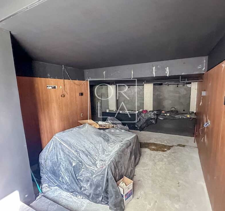 Espaço interno em obras com acabamento em madeira e concreto.