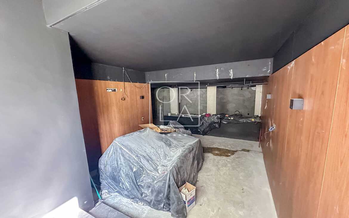 Espaço interno em obras com acabamento em madeira e concreto.