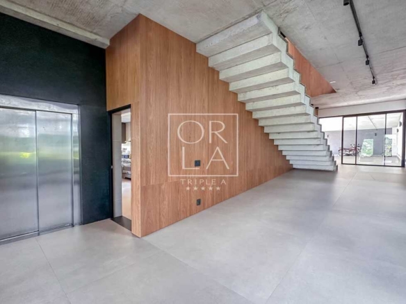 Hall de entrada com elevador privativo e escada de design moderno.