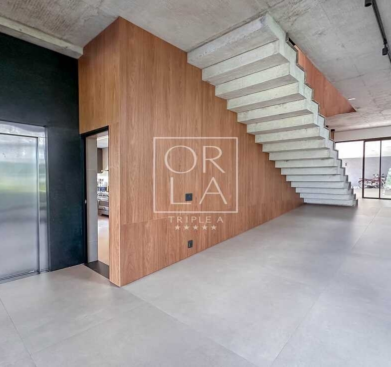 Hall de entrada com elevador privativo e escada de design moderno.