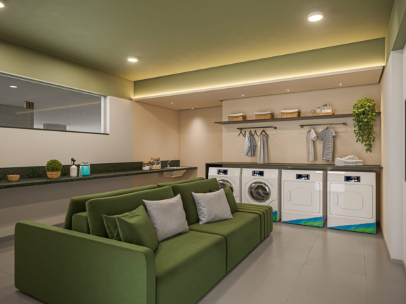 Lavanderia compartilhada com máquinas modernas de lavar e secar e um sofá verde para espera confortável.