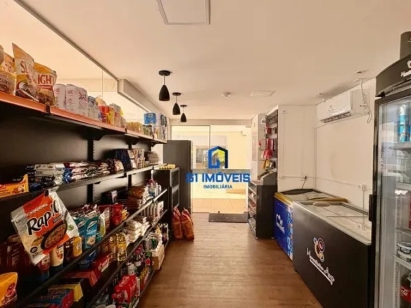 Conveniência interna do condomínio (market) com prateleiras de produtos e geladeiras de bebidas para moradores.