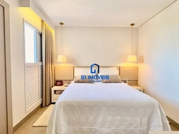 Quarto de casal com decoração clean, luminárias pendentes simétricas e cabeceira estofada em tons neutros.