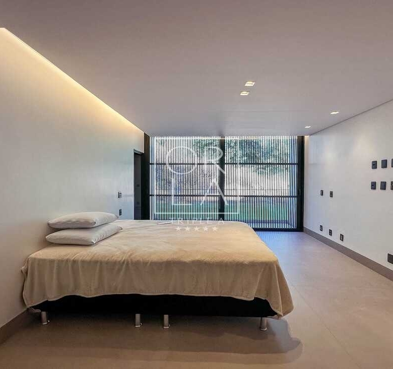 Quarto de hóspedes com design minimalista e painel de madeira no Aldeia do Vale.