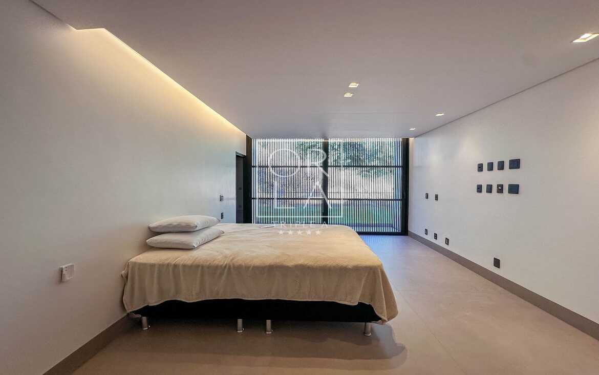 Quarto de hóspedes com design minimalista e painel de madeira no Aldeia do Vale.