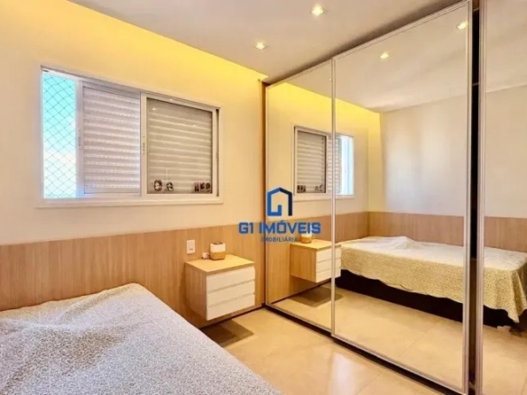 Quarto com amplo armário planejado de portas espelhadas e iluminação indireta no teto.