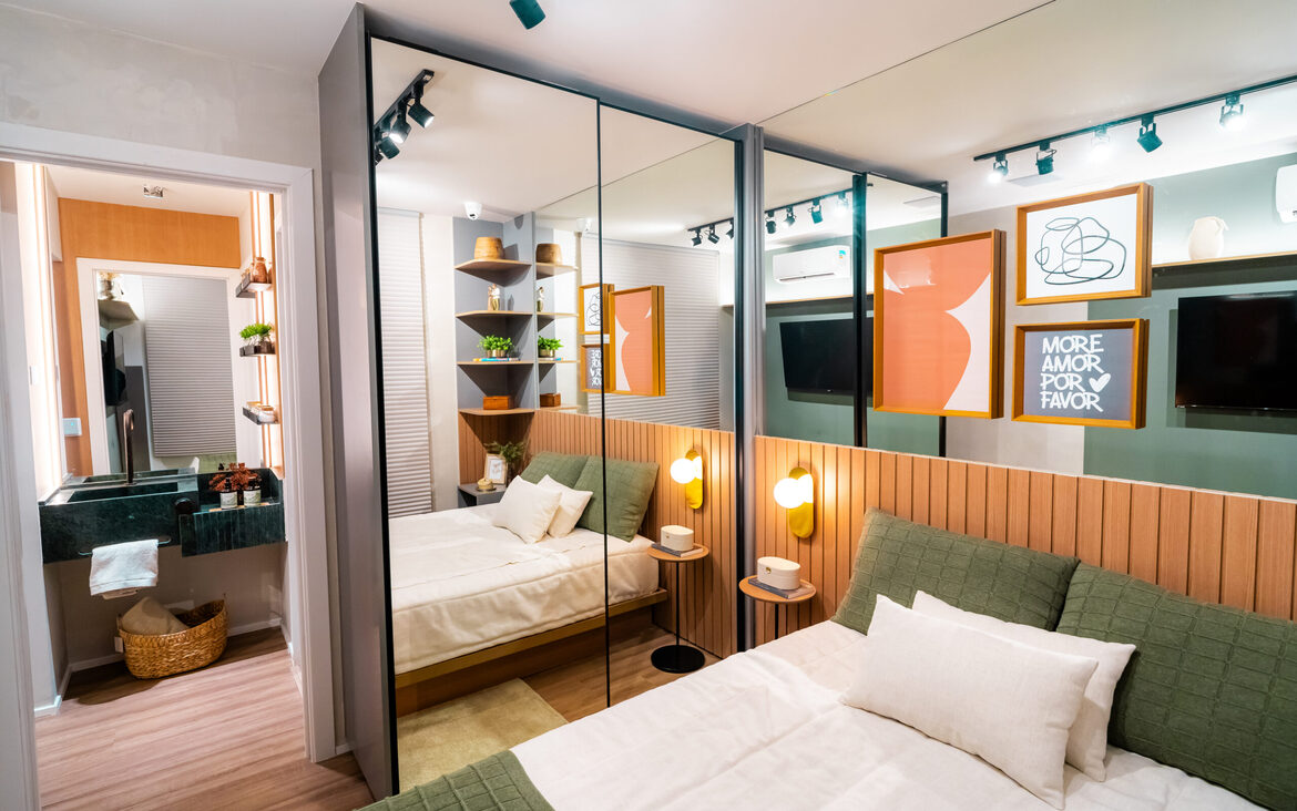 quarto-suite-espelho-now-111 Quarto decorado no Now 111 com closet espelhado, cama com enxoval verde e cabeceira ripada em madeira.