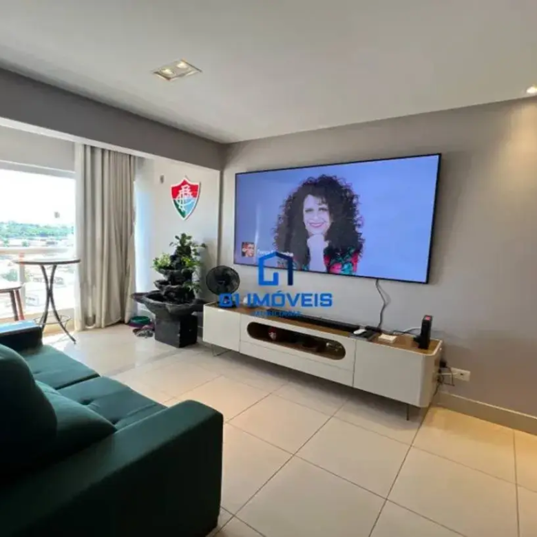 Sala de estar iluminada com sofá verde, TV e acesso à varanda no Residencial Modern Living.