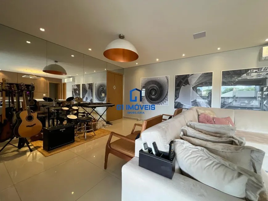 Sala com espaço musical, instrumentos e quadros de arte contemporânea.