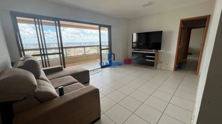 Sala de estar com sofá marrom, rack de TV e acesso à varanda em apartamento arejado.